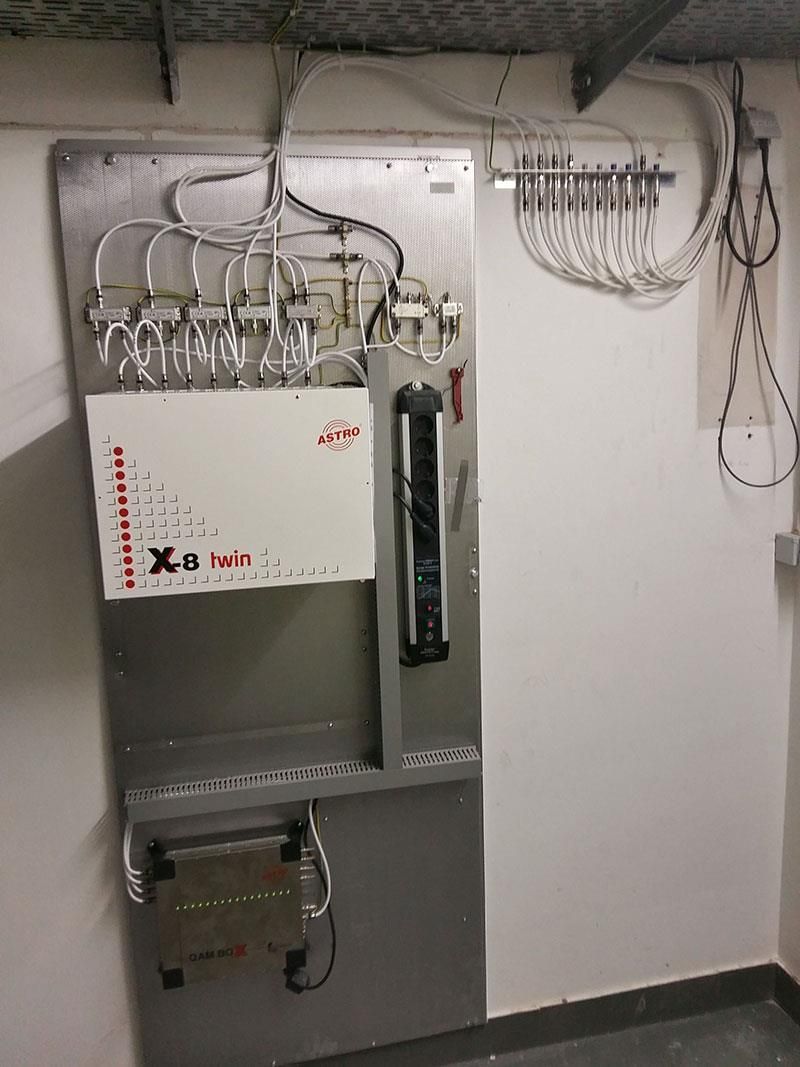 Eine Wand, an der viele Kabel hängen.