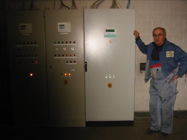 Ein Mann steht vor einer Reihe von Schaltkästen