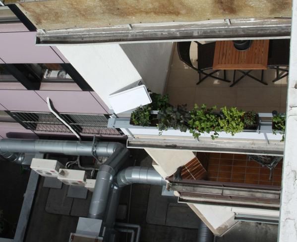 Eine Luftaufnahme eines Balkons mit Tisch und Stühlen