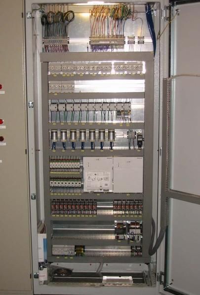 Eine große Schalttafel, von der viele Kabel herunterhängen.