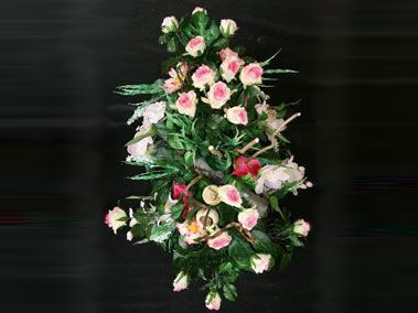 Des roses roses et blanches disposées avec des feuilles vertes sur un fond sombre.