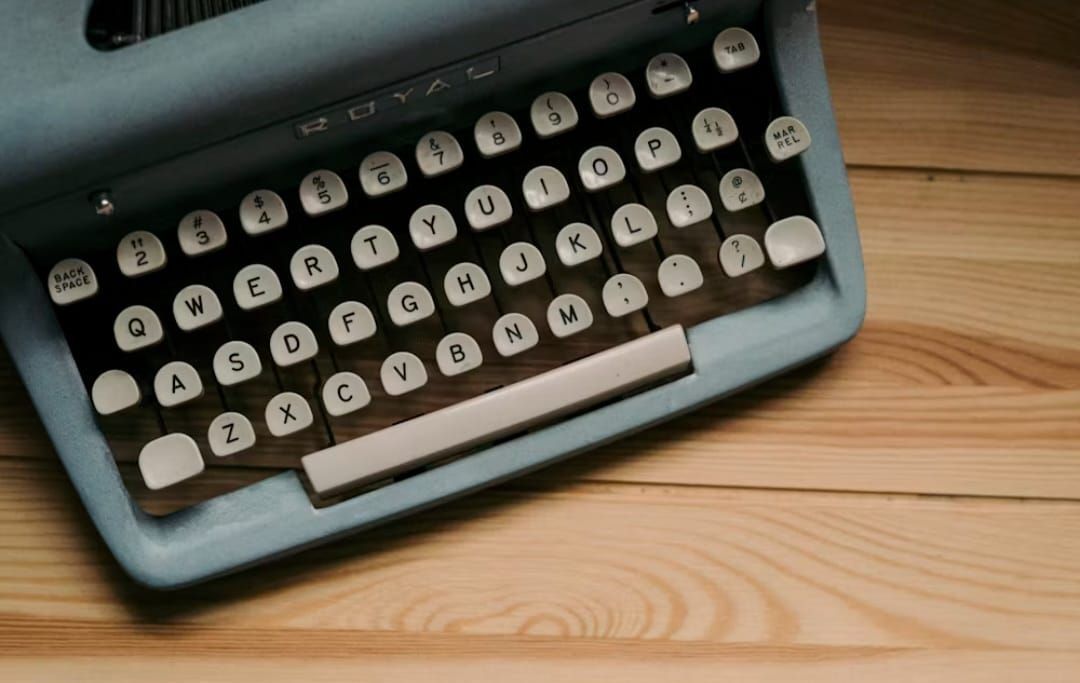 Auf einem Holztisch steht eine alte Schreibmaschine.