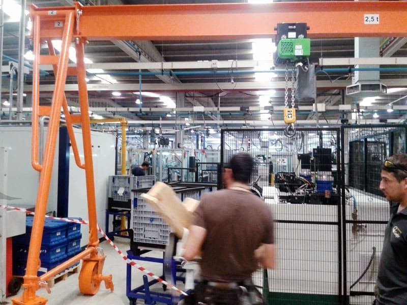 Un hombre con una camisa marrón está de pie en una fábrica.