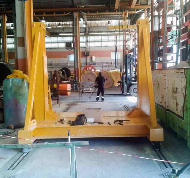 Un hombre está trabajando en una gran máquina amarilla en una fábrica.