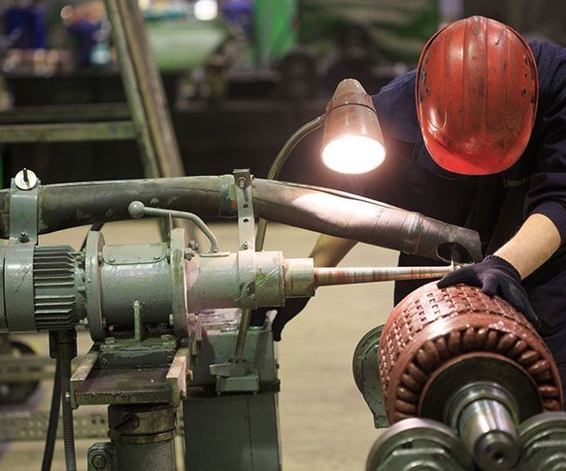 Un hombre que lleva un casco rojo está trabajando en una máquina.
