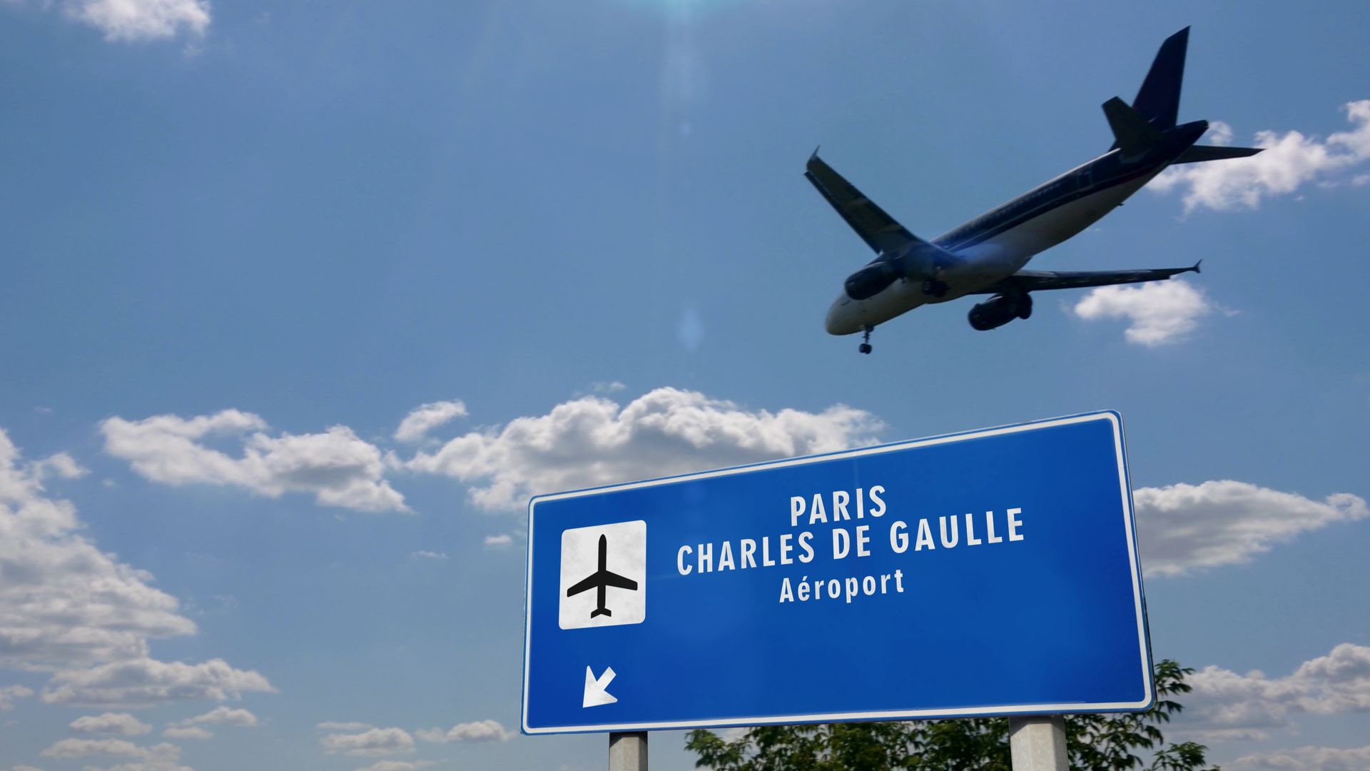 Panneau bleu indiquant l'aéroport Charles de Gaulle à Paris, avec un avion survolant le ciel bleu.
