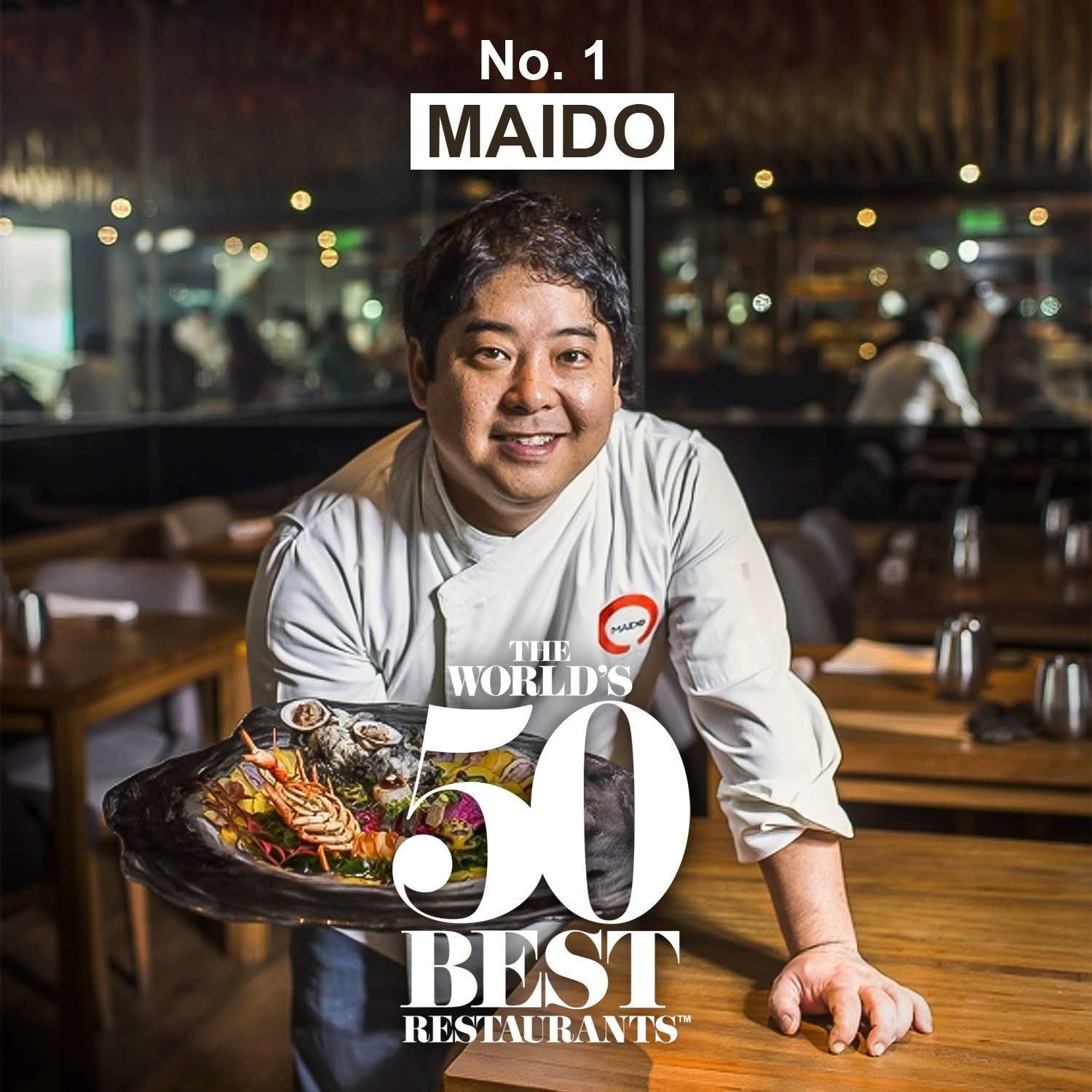 Chef con bandeja de comida, sonriendo. Nombre del restaurante: Maido, número 1 según el logo de 