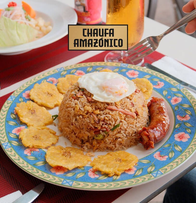 Plato de Chaufa Amazónico con huevo frito, salchicha, plátanos fritos y arroz.