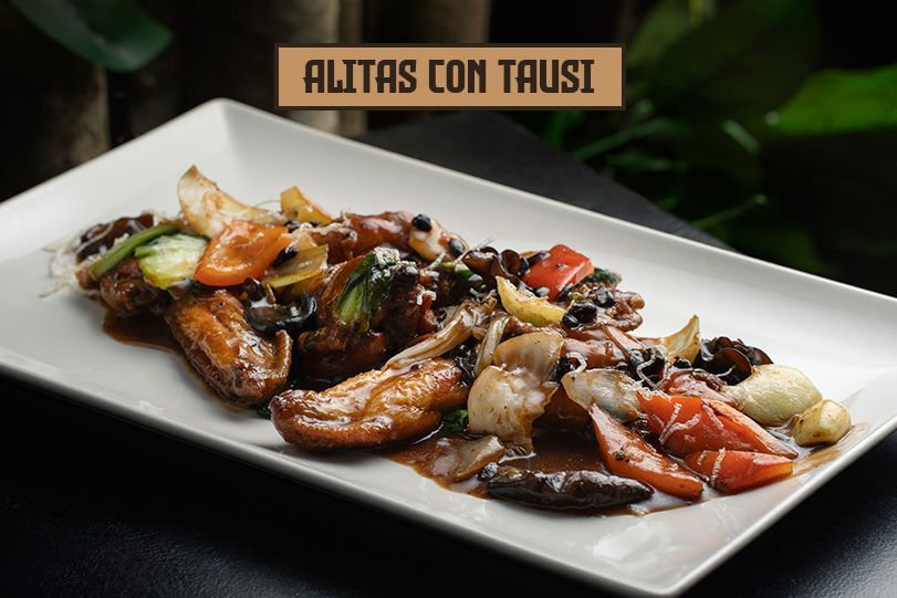 Alitas con verduras y salsa en plato rectangular blanco; texto: 