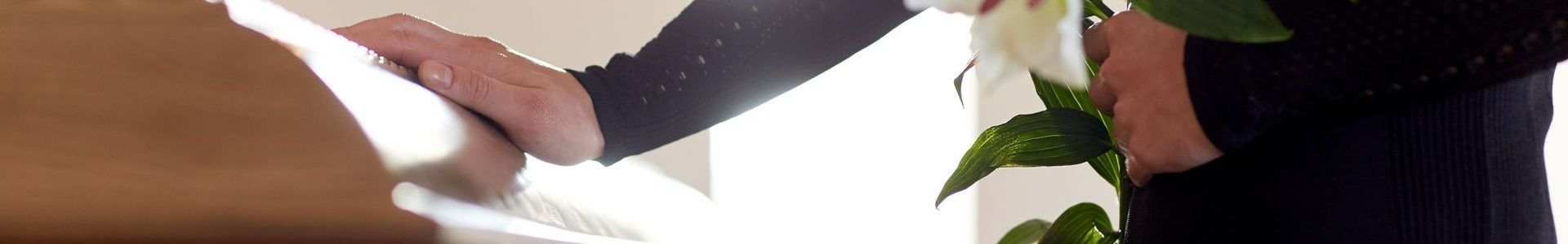 Une personne âgée signe un papier dans un bureau