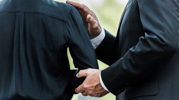 Un homme pose une main sur l'épaule d'un autre