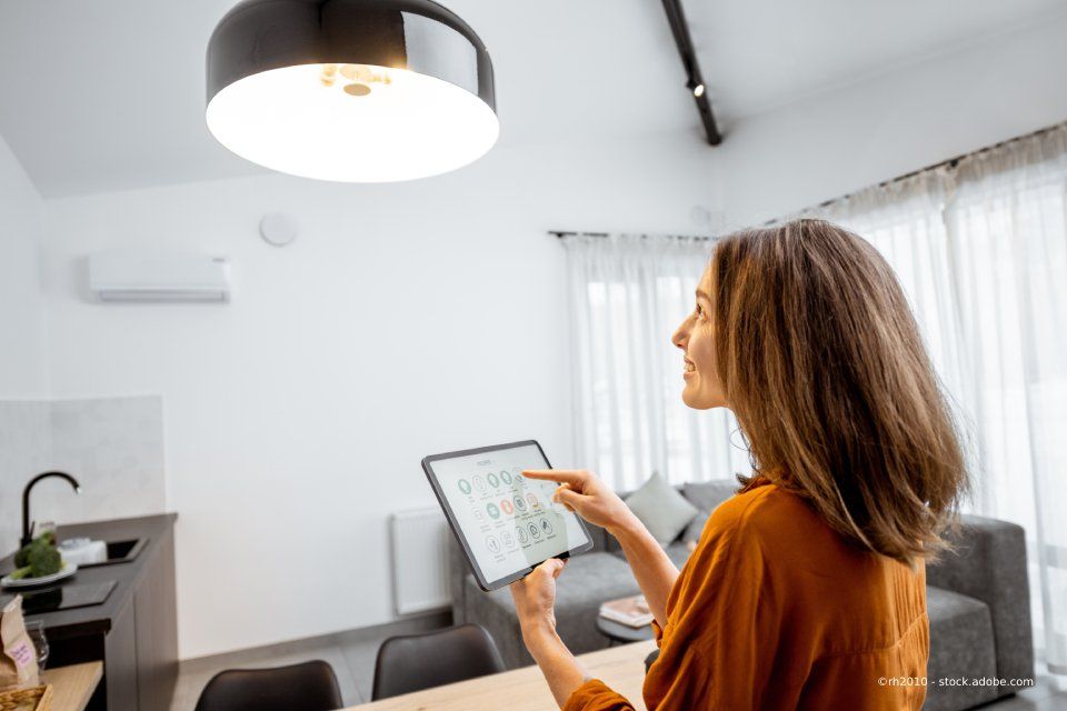 Kundin von Elektro Hoster bedient die Beleuchtung im Wohnzimmer per Tablet