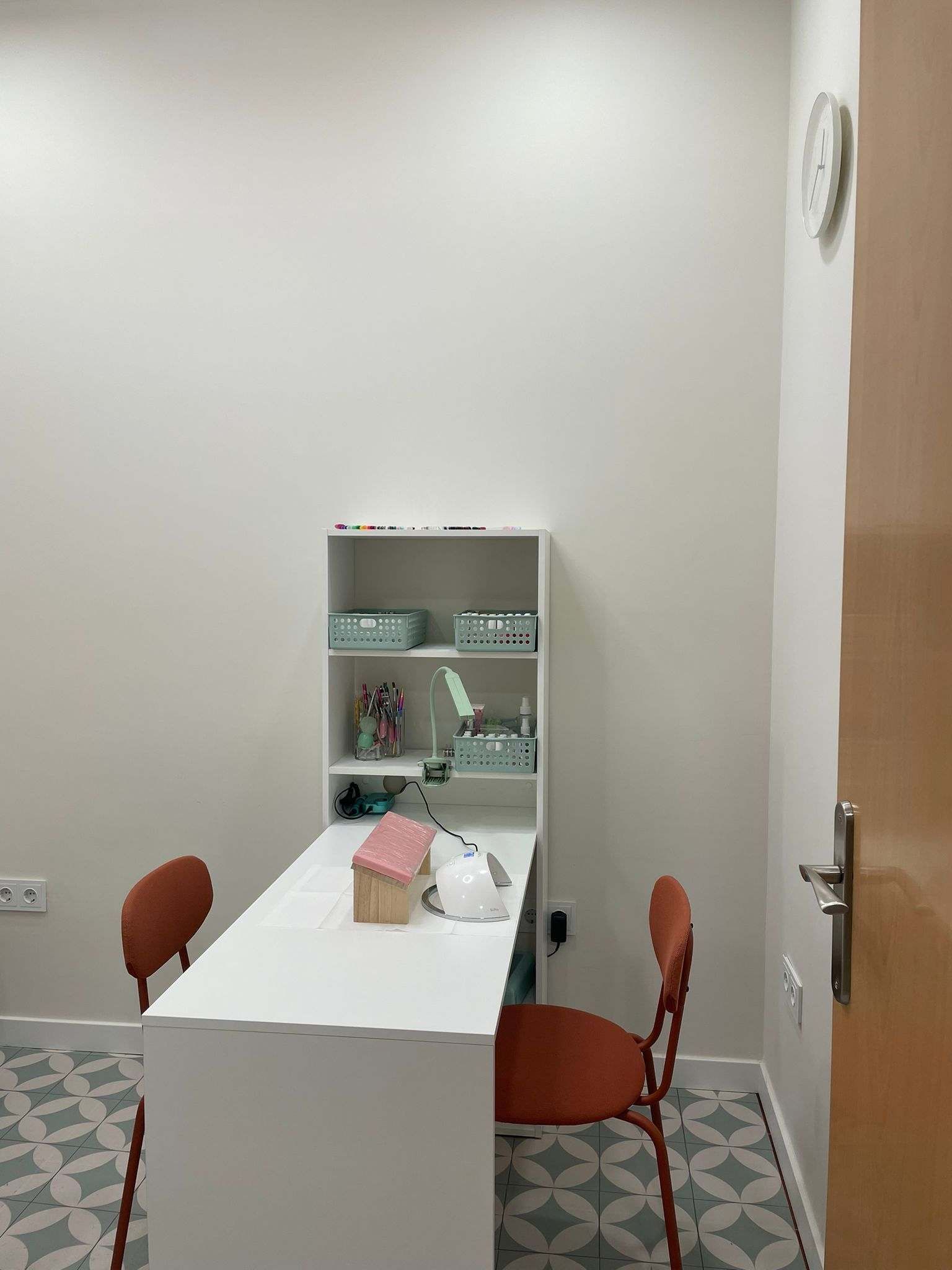 Una habitación con una mesa y sillas y un reloj en la pared.