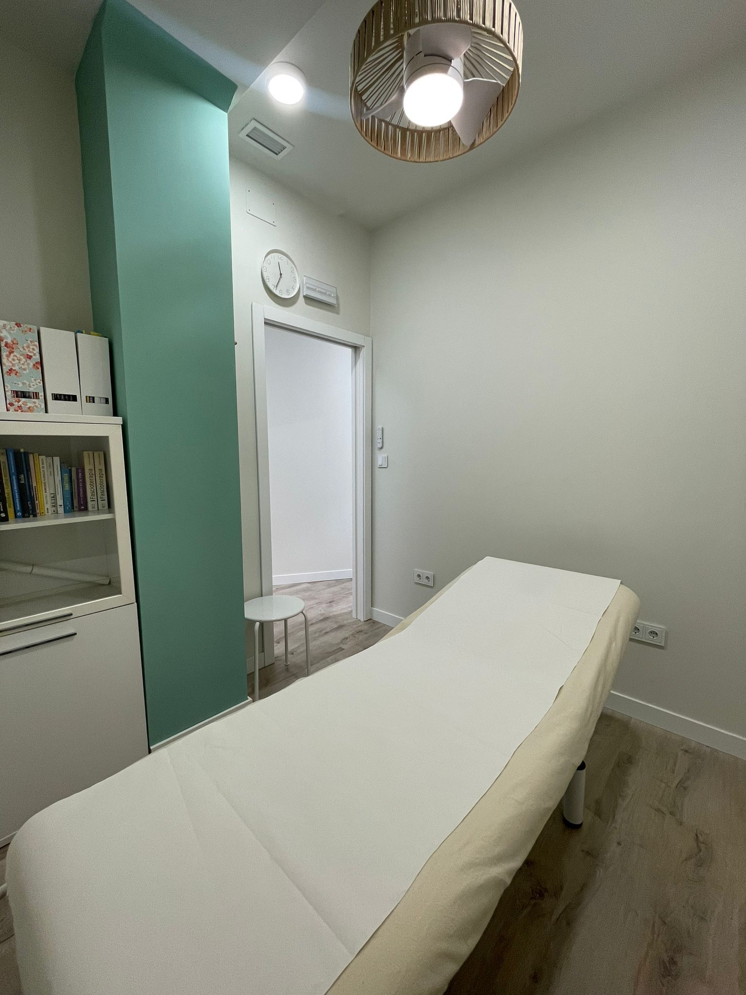 Una habitación con una cama y un reloj en la pared.