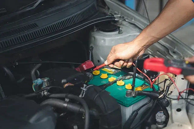 Una persona está cargando una batería de automóvil con un cargador.