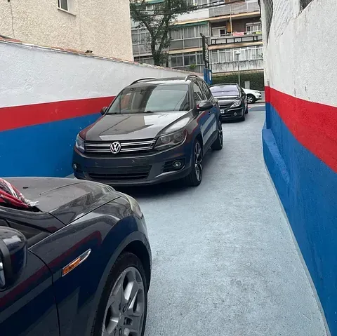 Una fila de coches están aparcados uno al lado del otro en un estacionamiento.