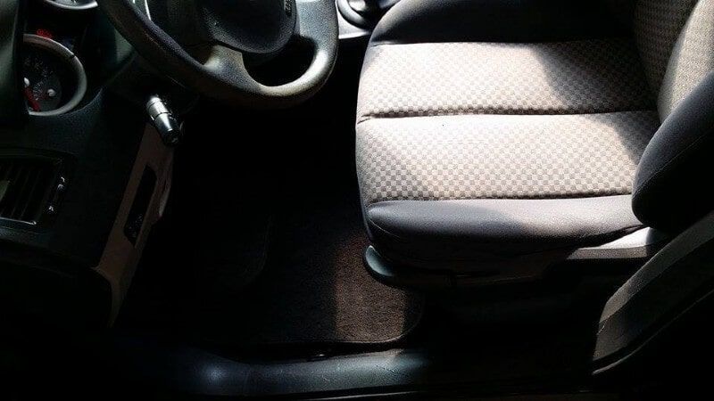 Εσωτερικό αυτοκινήτου με τιμόνι, κάθισμα συνοδηγού και κεντρική κονσόλα, λουσμένα στο φως του ήλιου