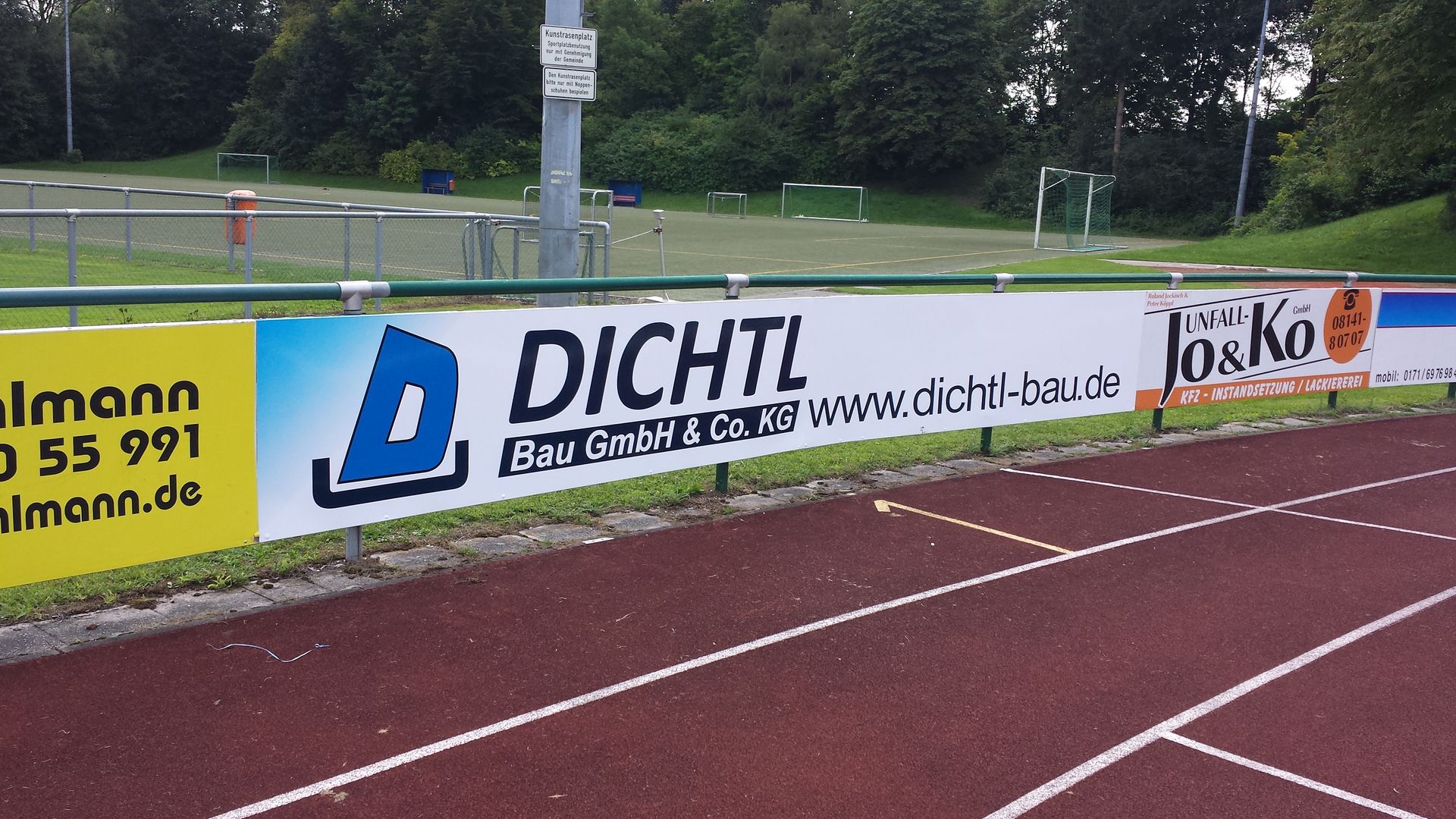 Werbebanner auf einer Leichtathletikanlage mit Sponsorenlogos und dem Firmennamen „DIICHTL“.