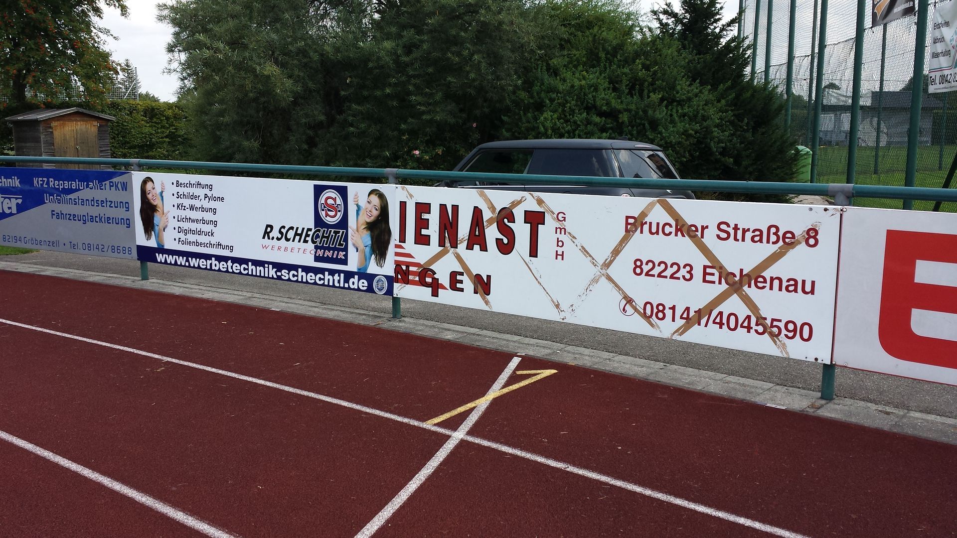 Bandenwerbung auf einem Sportplatz.