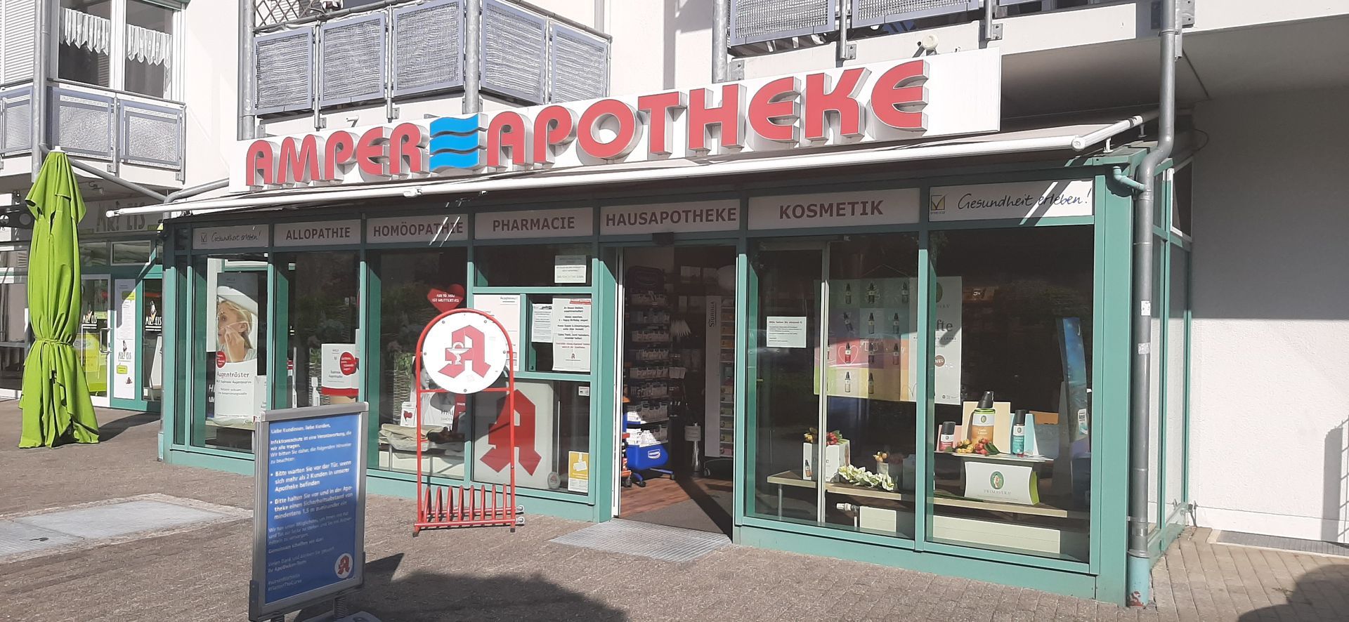 Eine Apotheke mit rot-blauen Leuchtbuchstaben.