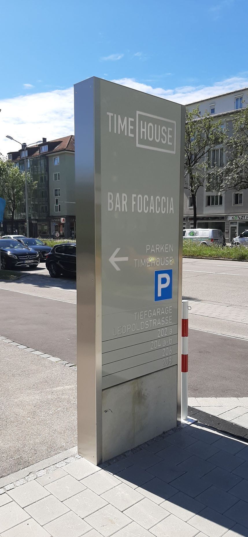 Werbepylon zum „Tine House“ mit Parksymbol, das die Richtung anzeigt.