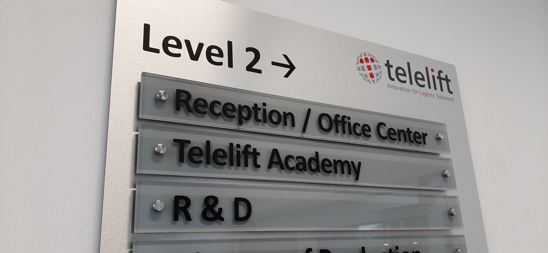 Beschilderung für Telelift auf Ebene 2 mit Zielen für Rezeption/Büro, Telelift Academy und F&E.