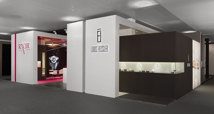 Uhrenausstellung mit weißen und schwarzen Vitrinen, in denen Luxusuhren präsentiert werden.