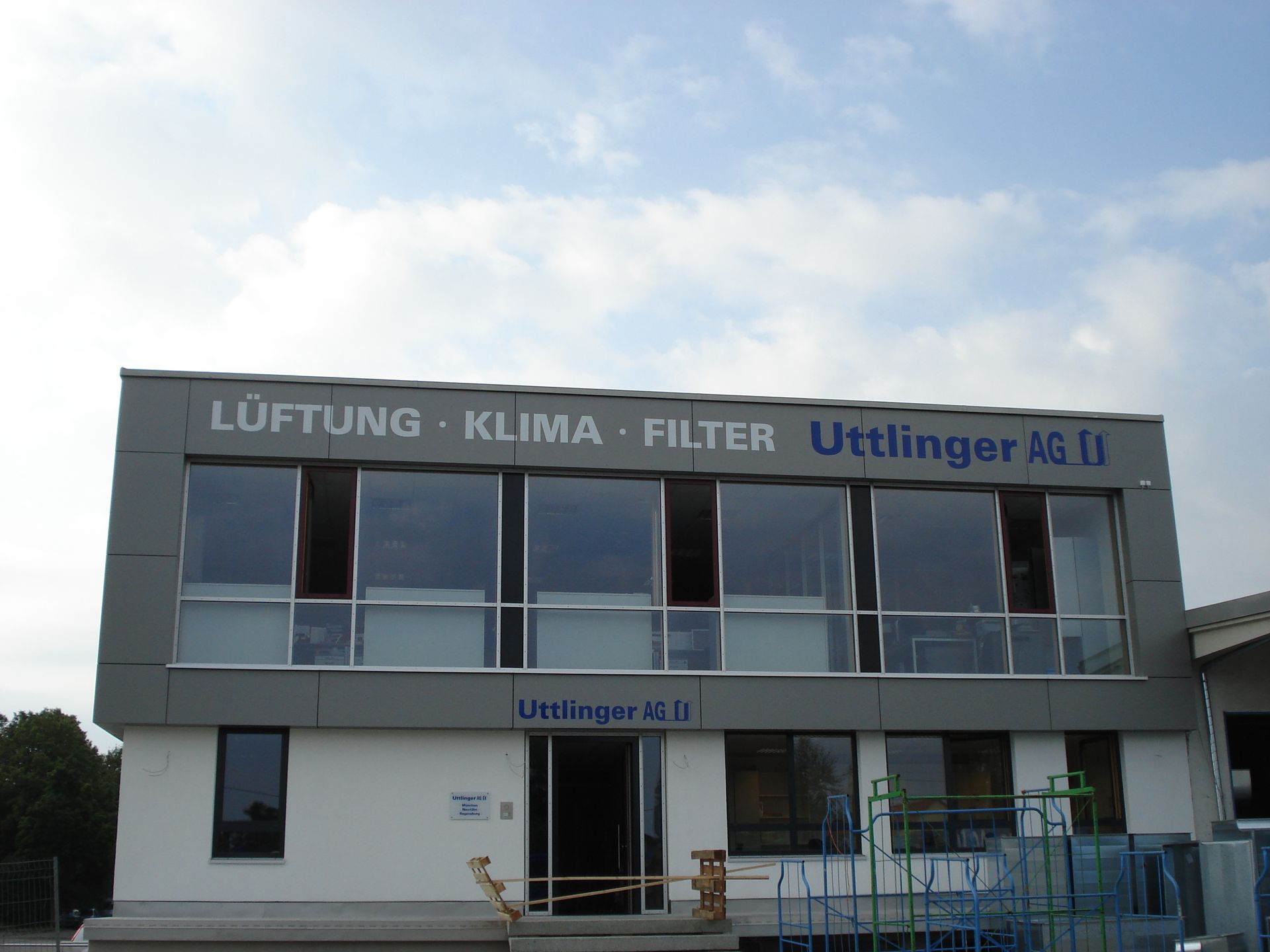 Bürogebäude mit großen Fenstern; Beschilderung „LüFTUNG • KLIMA • FILTER Uttlinger AG“.