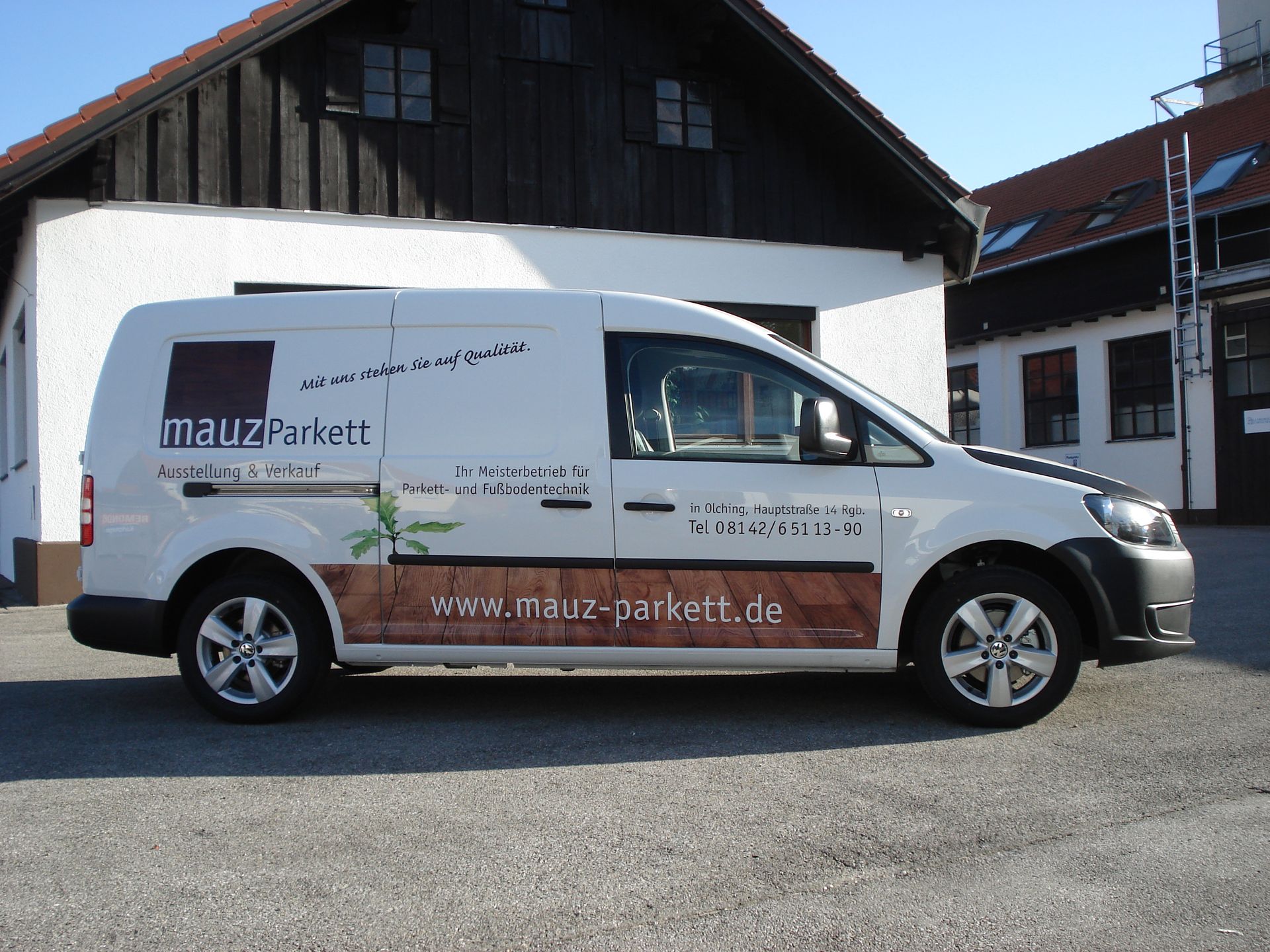 Weißer Lieferwagen mit „Malz Parkett“-Logo parkt vor einem Gebäude.