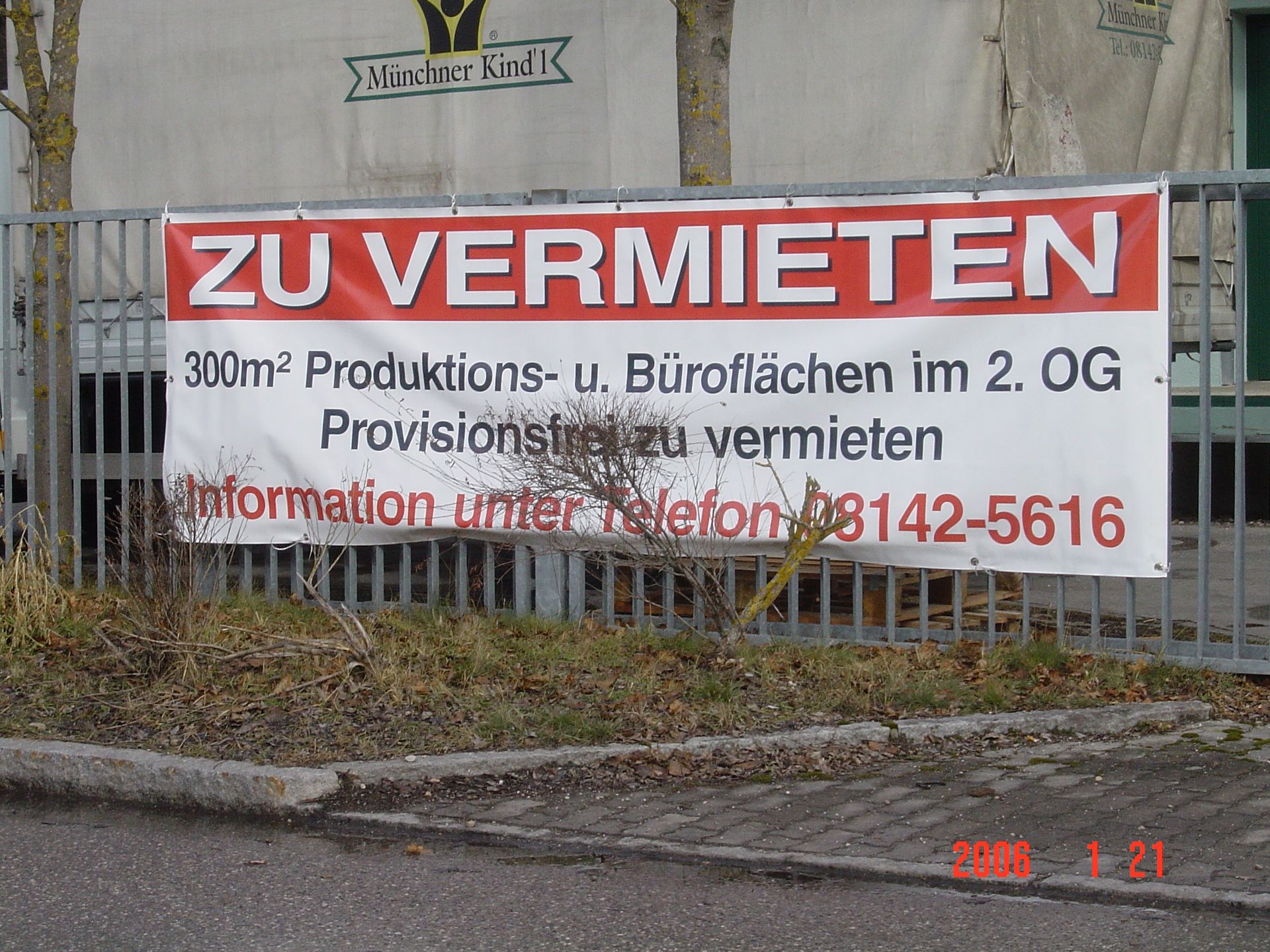 Banner an einem Zaun: „ZU VERMIETEN“ mit Angaben zu 300m² Bürofläche zur Miete, inklusive Telefonnummer.
