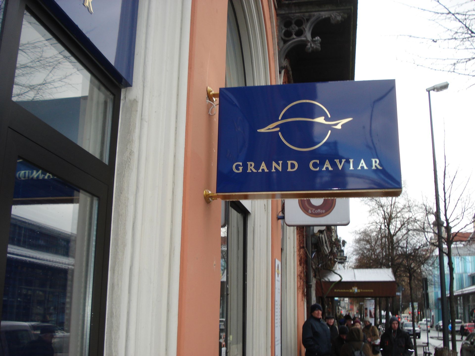 Grand Caviar“-Leuchtkasten an einer Gebäudefassade.