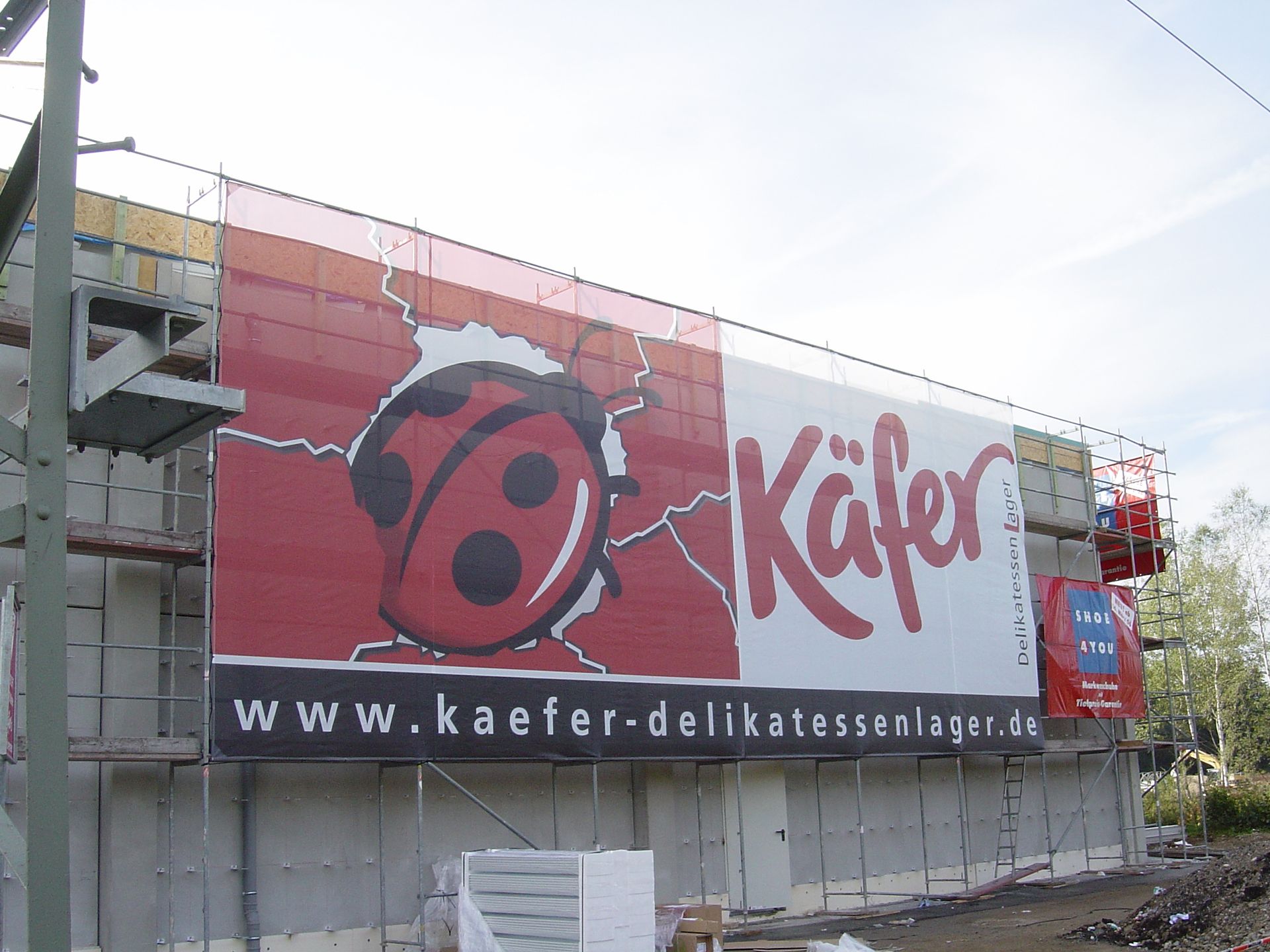 Werbetafel im XXL-Format für das Feinkostgeschäft „Käfer“.