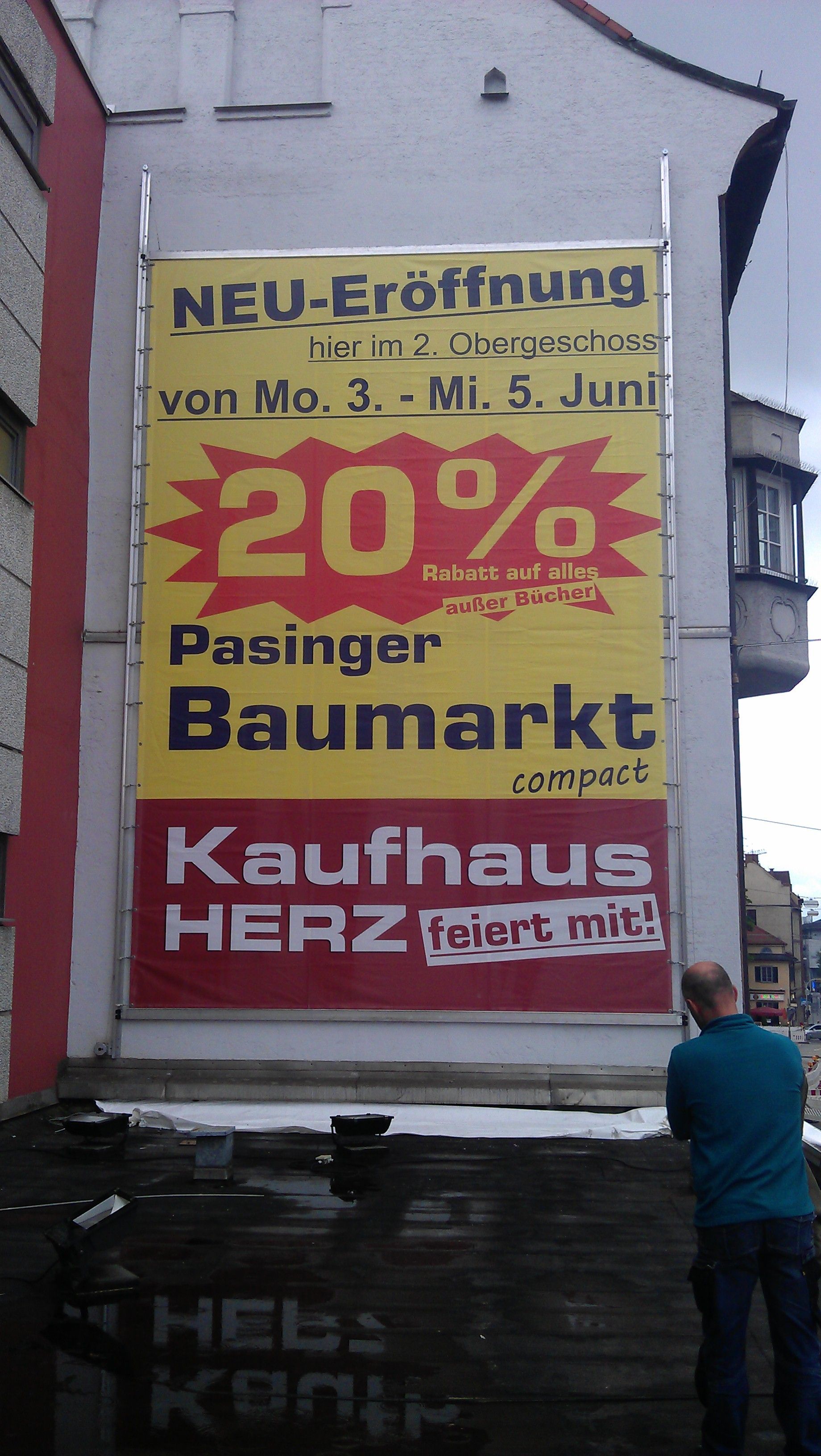 Schild im XXL-Format mit der Aufschrift „NEU-Eröffnung“.