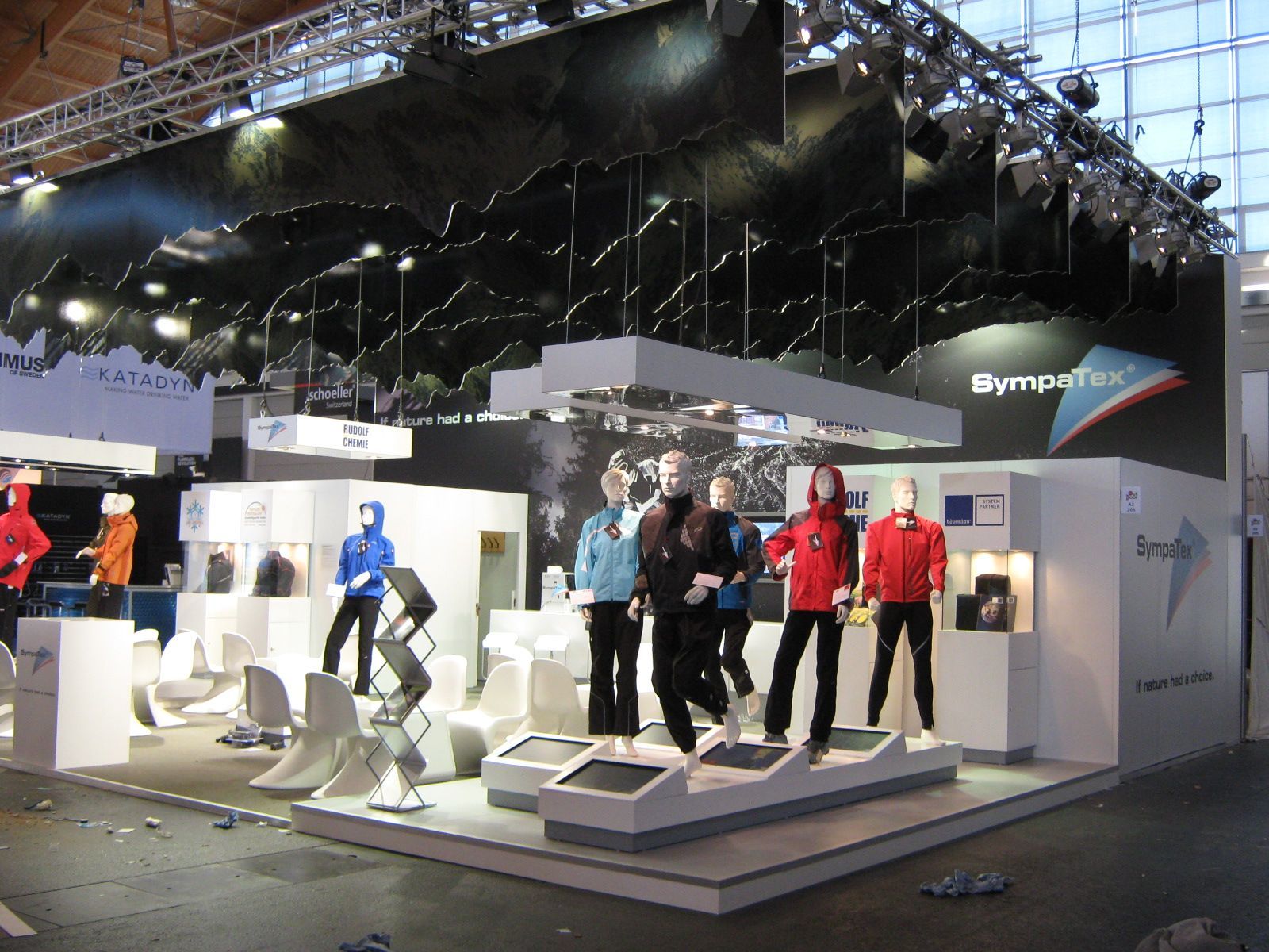 Ausstellung von Schaufensterpuppen in Sportkleidung an einem Messestand.
