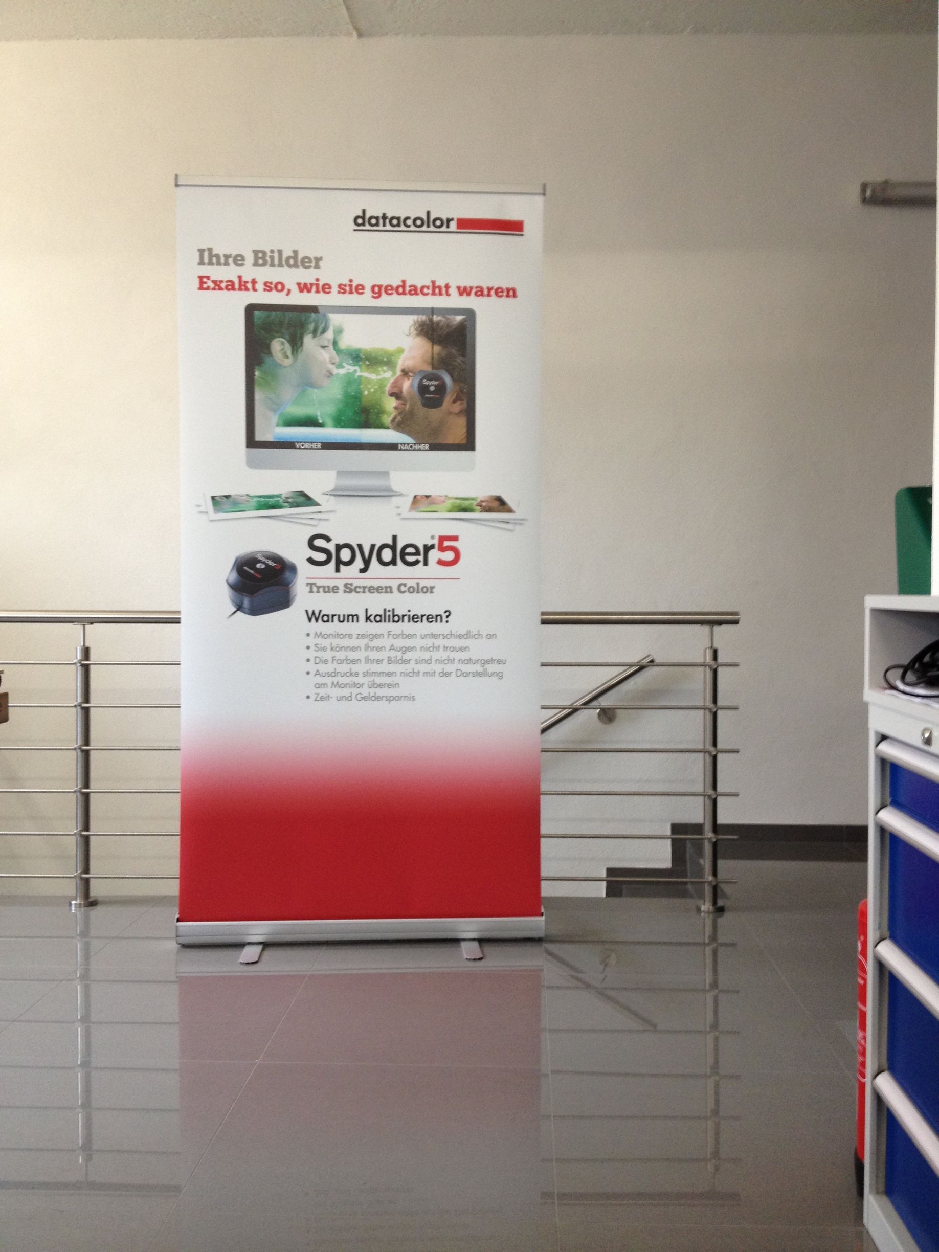 Bannerwerbung für Spyder5, ein Farbkalibrierungstool, in einer hellen Büroumgebung.