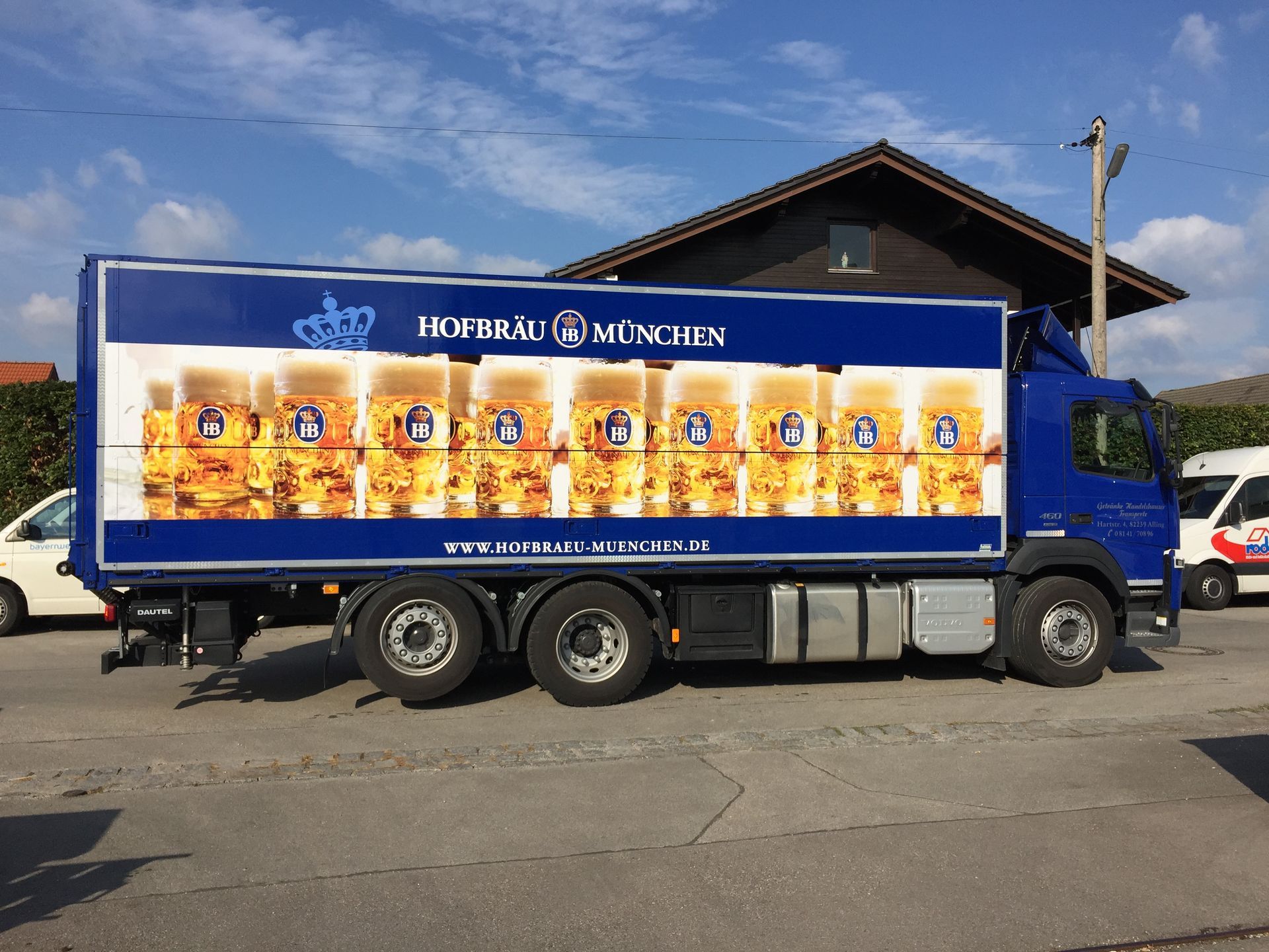 Blauer Bierlieferwagen von Hofbräu München, der auf einer Straße geparkt ist.