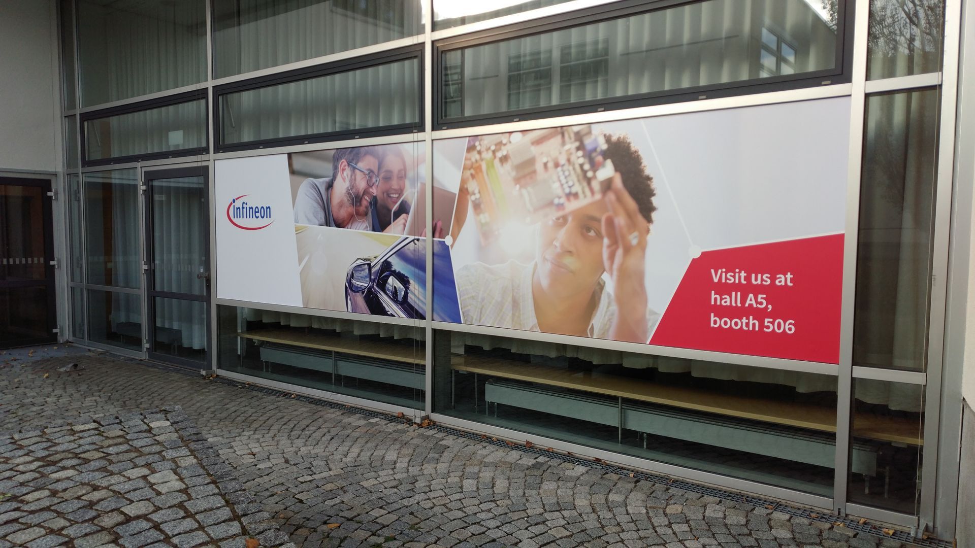 Großes Schaufenster mit Werbung mit menschlichen Figuren und Text.