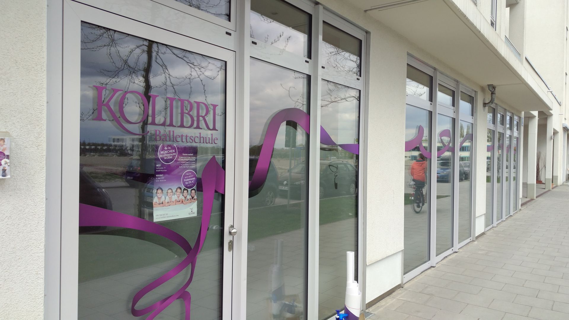 Außenansicht eines Schaufensters mit großen Fenstern; das Geschäft „Kolibri“ ist mit violetten Grafiken versehen.