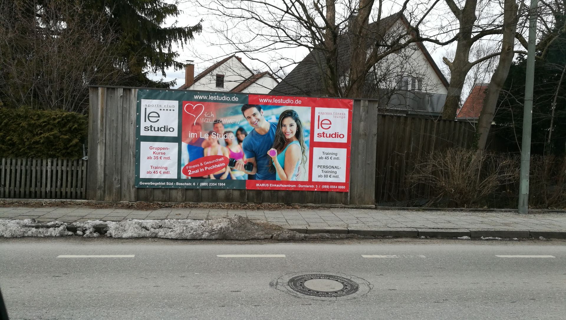 Werbetafel im XXL-Format an einem Holzzaun.