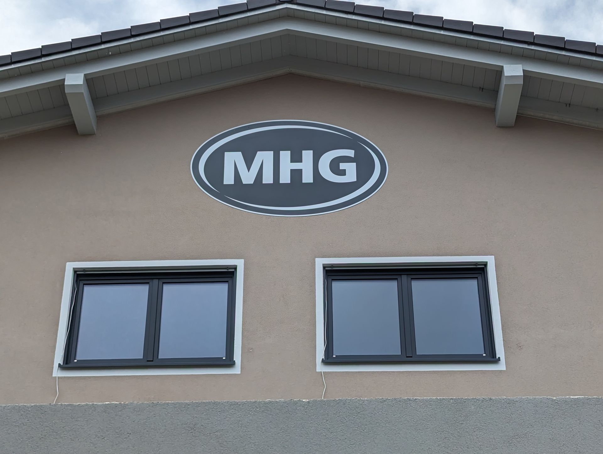 Schild mit dem Text MHG an einem Gebäude