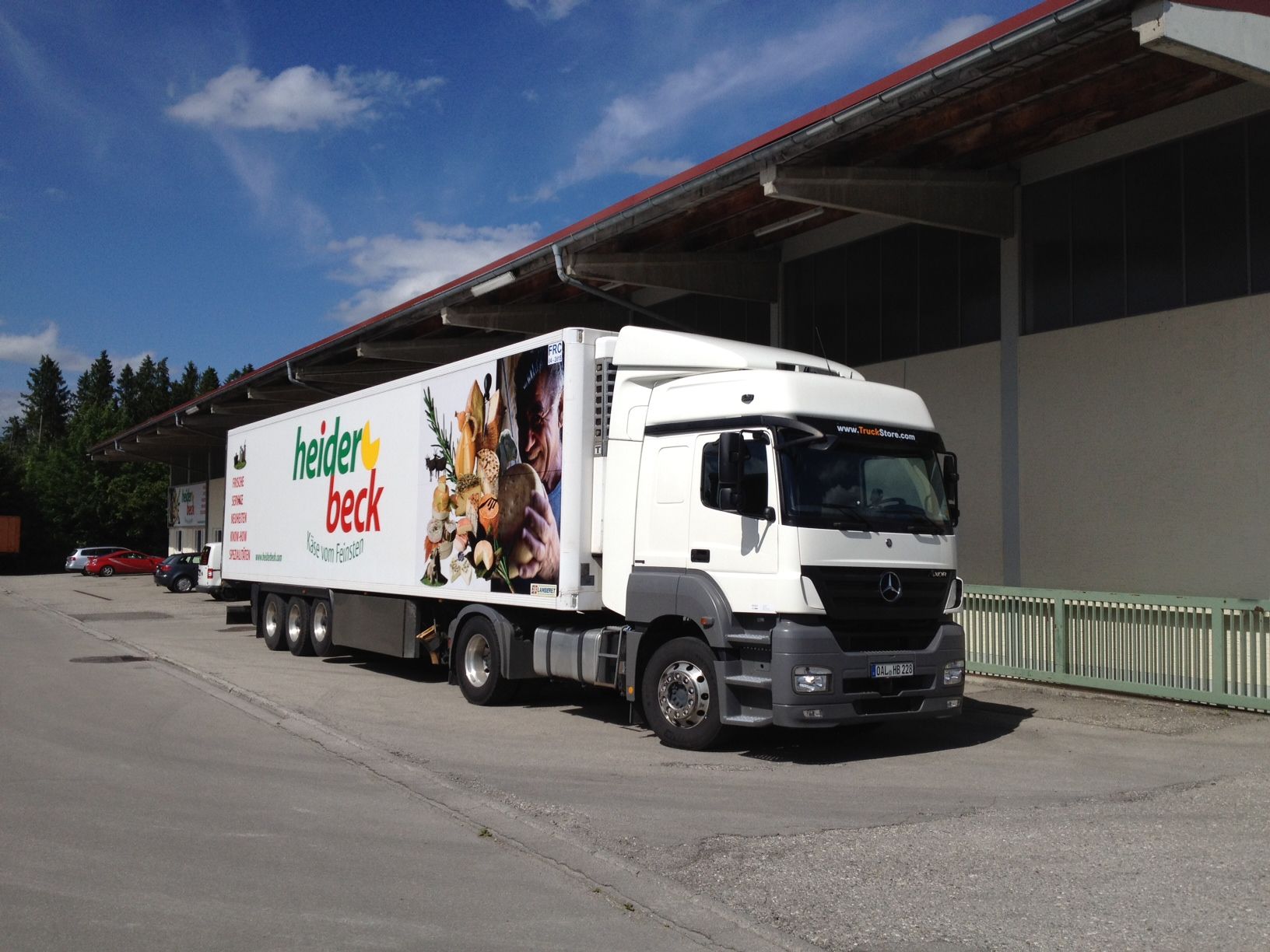 Weißer Kühlsattelschlepper mit „Beider Beck“-Logo an der Laderampe geparkt.