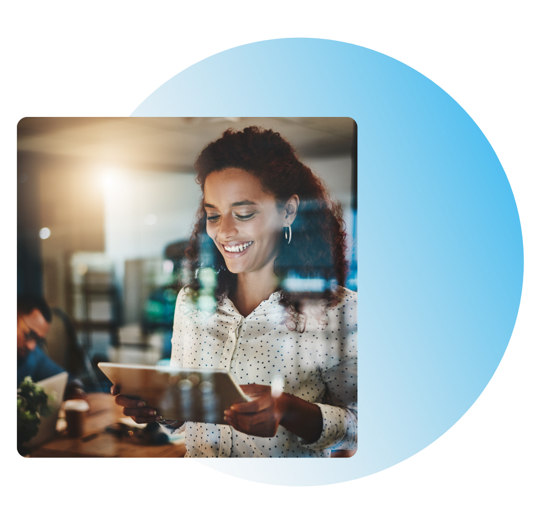 Donna che sorride mentre guarda un tablet, mentre lavora in un bar.