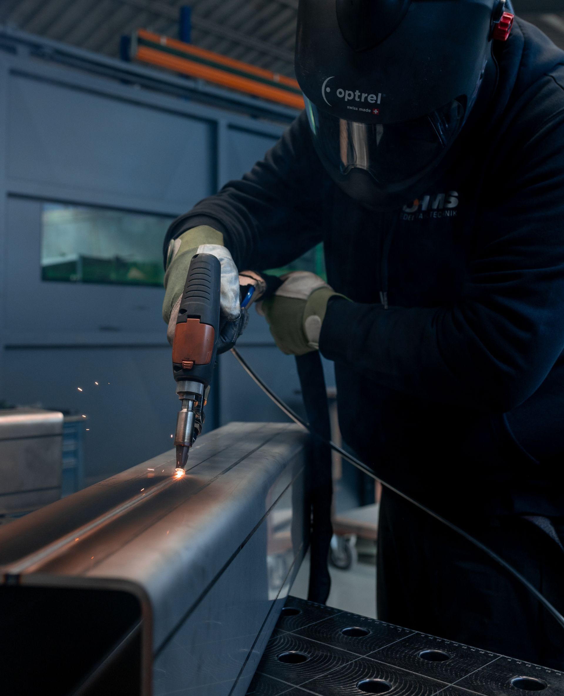 Ein Roboter schweißt in einer Fabrik ein Stück Metall.