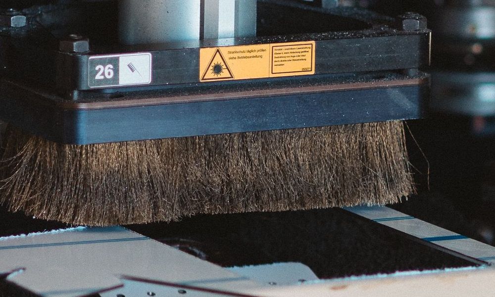Eine Maschine schneidet ein Stück Metall mit einem Muster darauf.