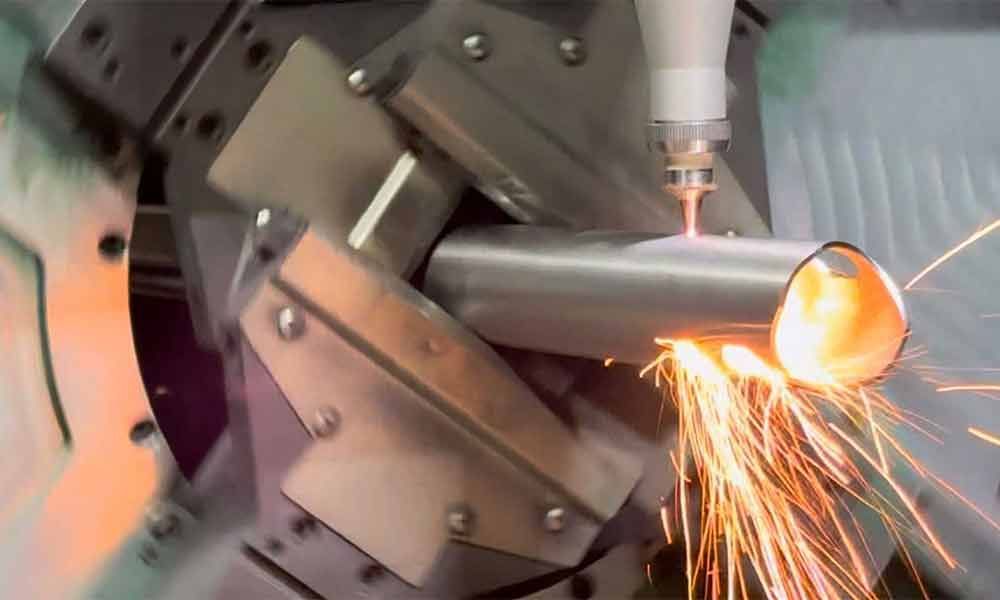 Eine Maschine schneidet ein Metallrohr, wobei Funken austreten.