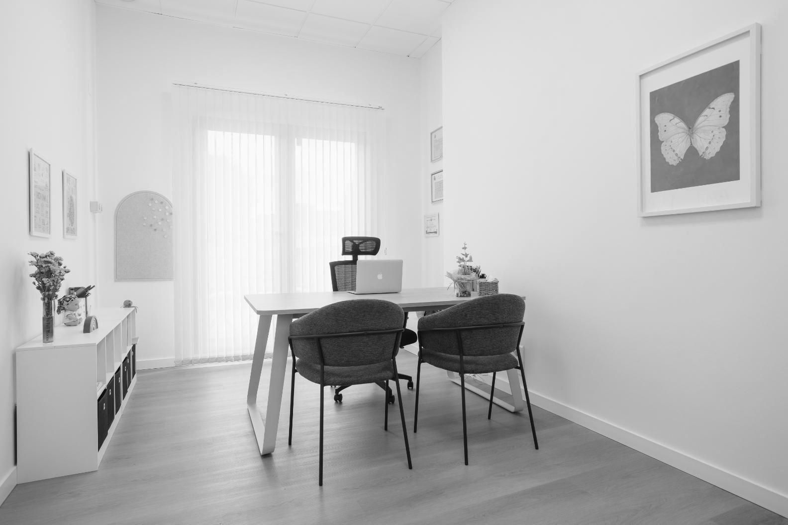 Tres personas observan una tableta en una oficina bien iluminada. Dos mujeres y un hombre sonríen 