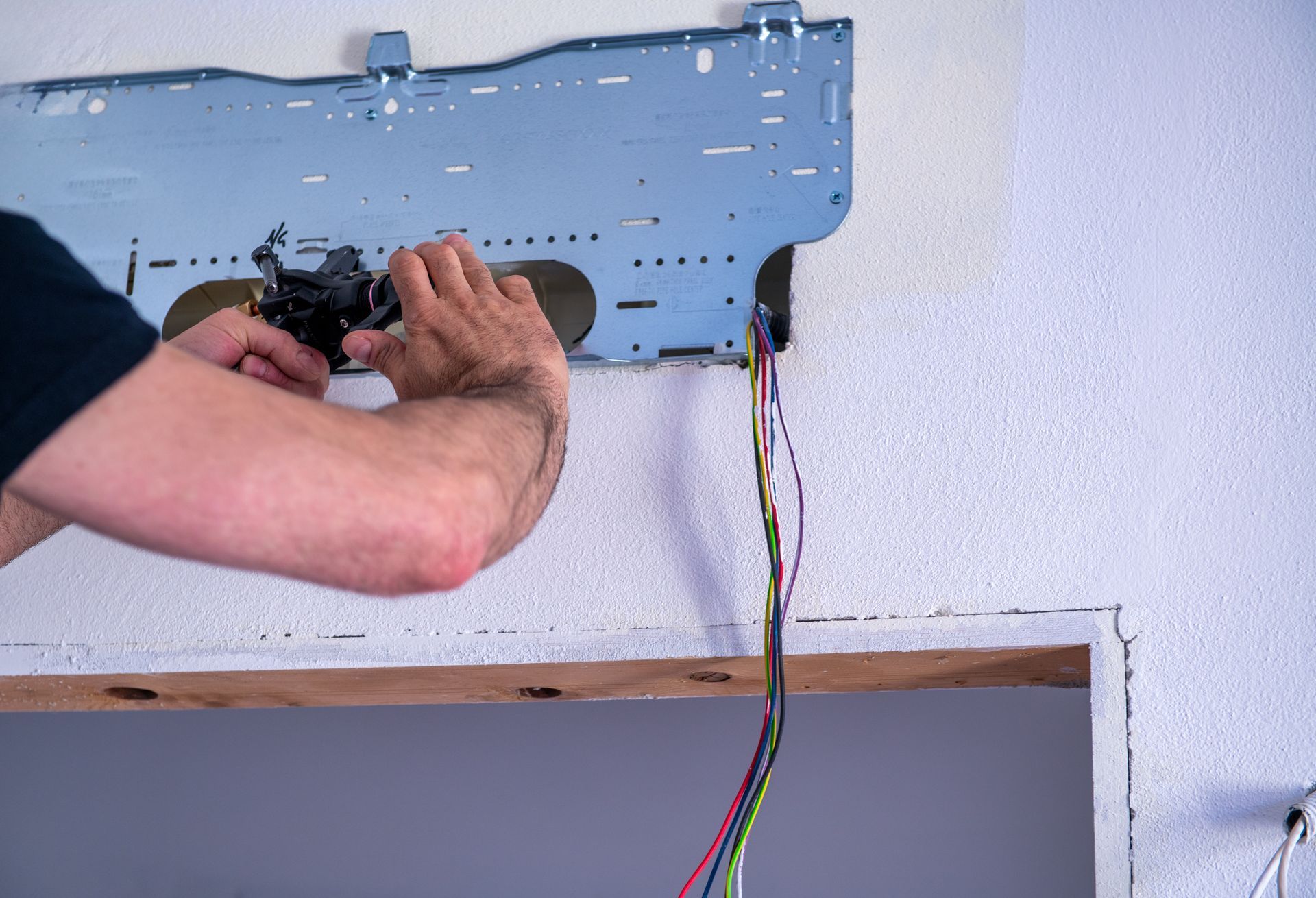 Ein Mann installiert eine Klimaanlage an einer Wand.