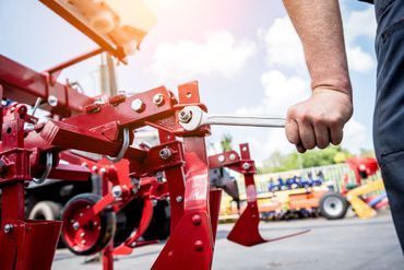 Mitarbeiter von Urilandtechnik AG schraubt an Landmaschine