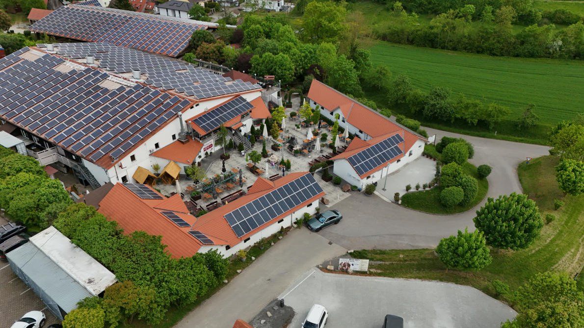 Ein Holztisch mit Brezeln und einem Glas Bier.
