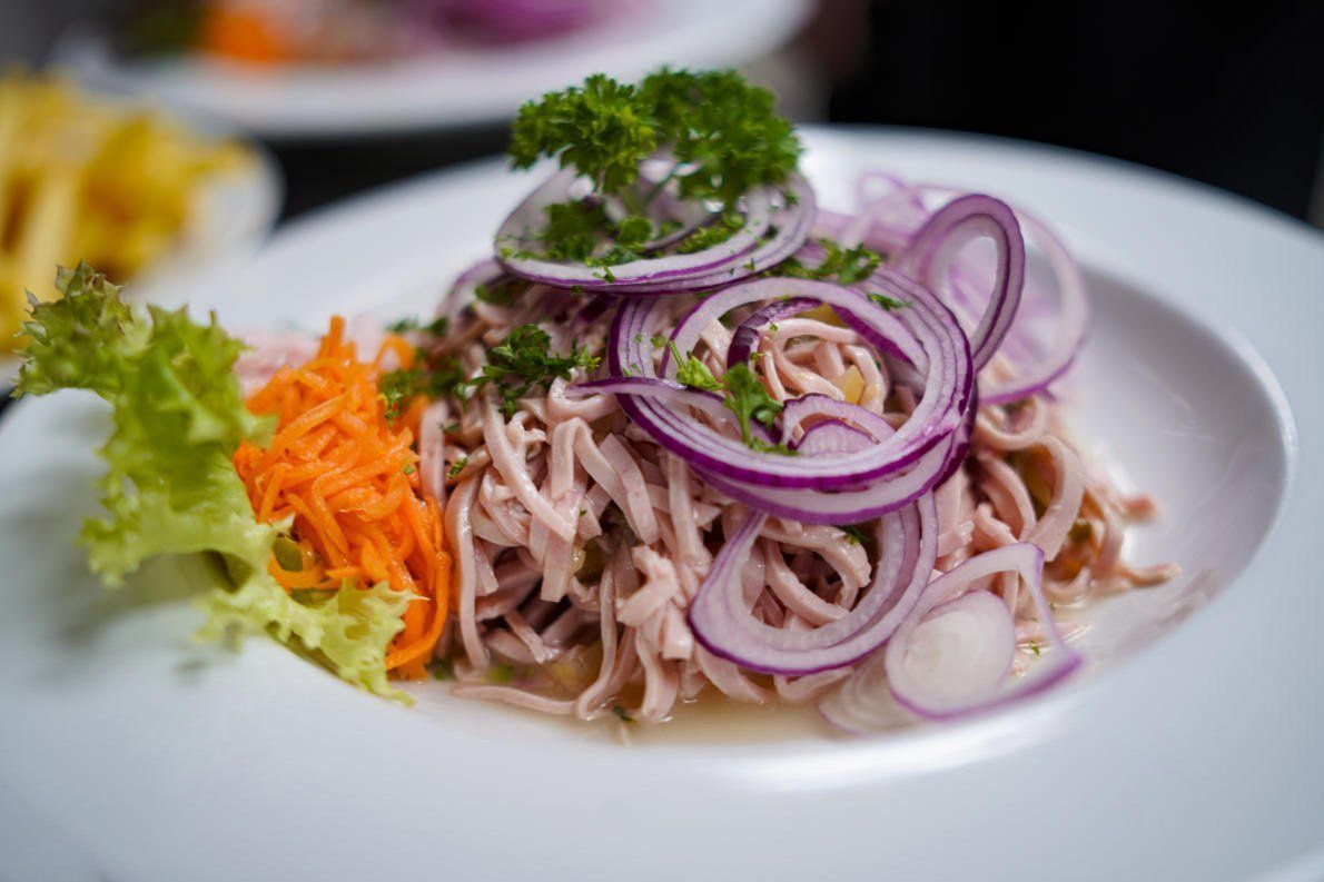 Ein schwarzes Menübuch mit goldenen Ecken auf weißem Hintergrund